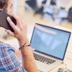 man on phone at computer