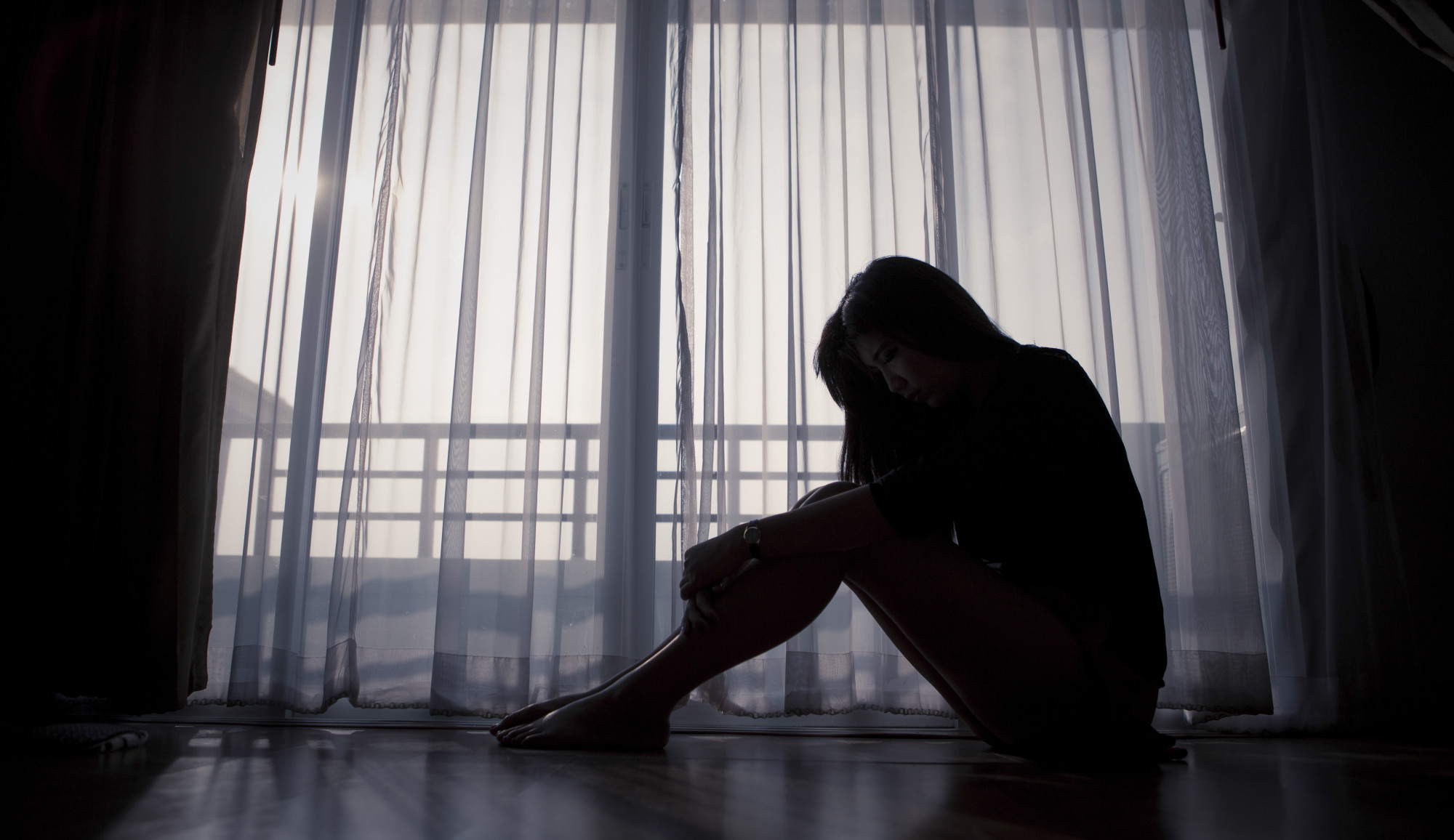 depressed woman sitting on floor